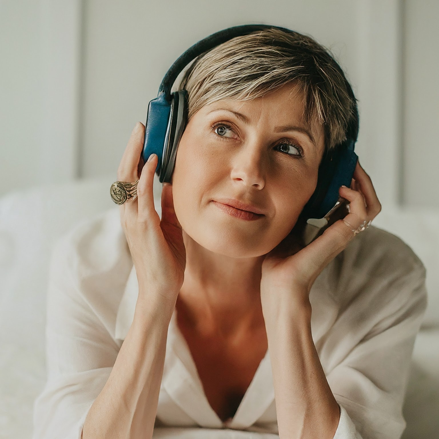Woman wearing headphones and listening to relaxing rest music in bed.
