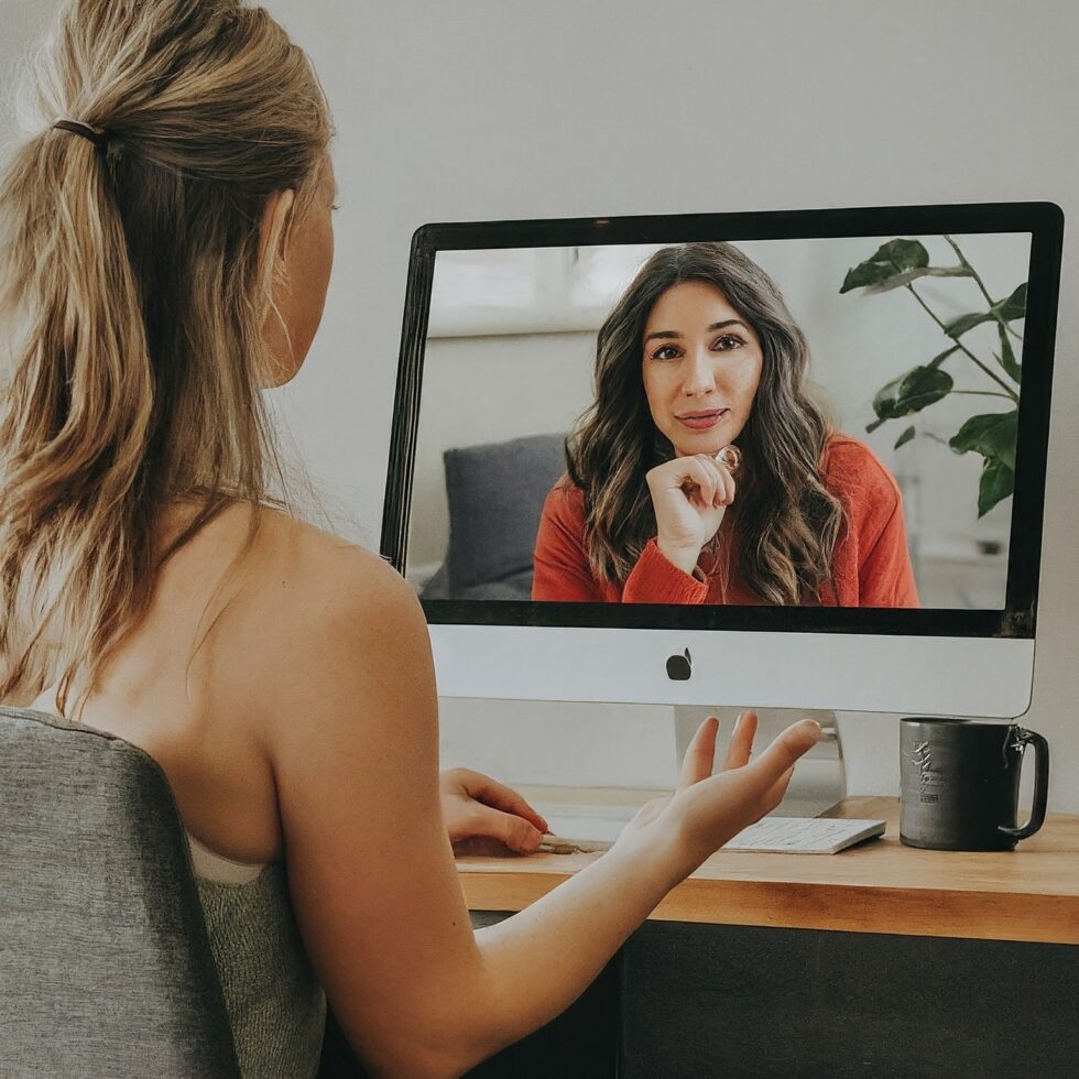Woman receiving virtual sleep coaching from a specialist during an online video session at home.