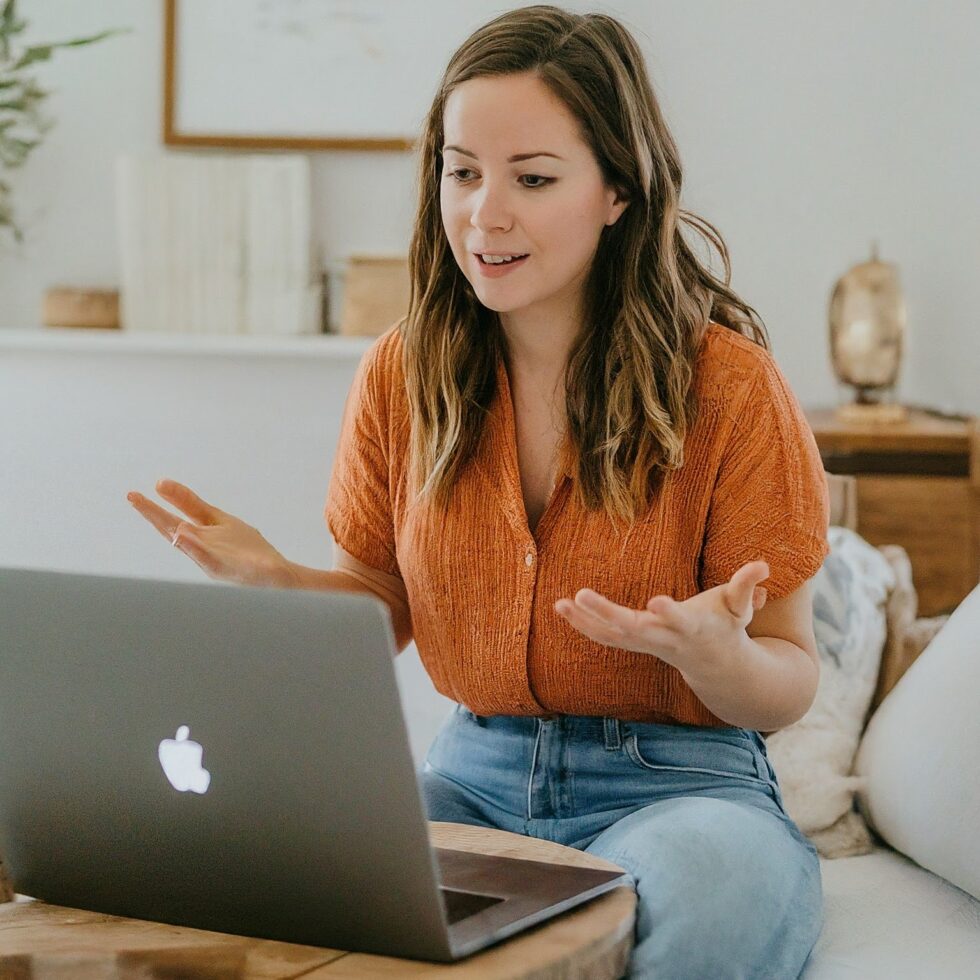 Online sleep coach speaking with a client during a virtual coaching session on a laptop from a home setting.